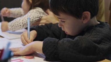 Ödev zamanı. İlkokul çocuğu ev ödevini annesiyle yapıyor, o da kız kardeşine bakıyor. Öğrenci çocuk şurada oturuyor.