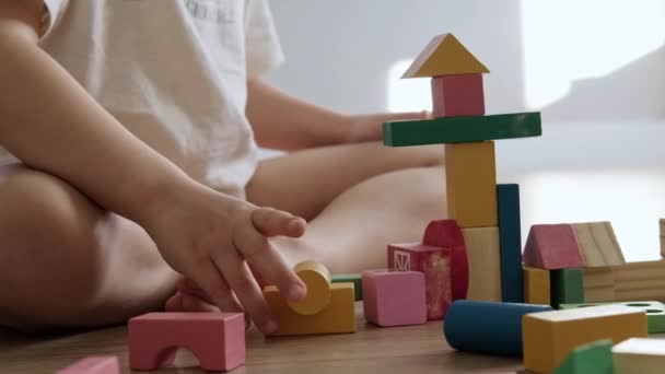 一个男孩儿用方块玩具建造的塔楼的特写。幼儿教育和创意玩具和游戏。儿童发展. — 图库视频影像