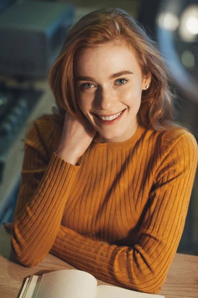 Close-up front view portrait of a woman with red hair, looking at camera with friendly face and smiling. Beautiful girl. — Stockfoto