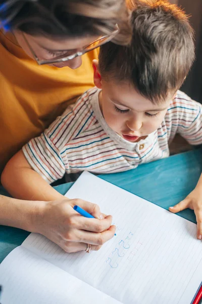 Visão superior de mãe e filho mãos escrevendo números. Escola familiar. Número de contagem — Fotografia de Stock