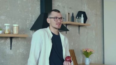 Kafkasyalı genç işadamının mutfağa telefon etmesi, elma yemesi. Sağlıklı bir yaşam tarzı. Modern iletişim.