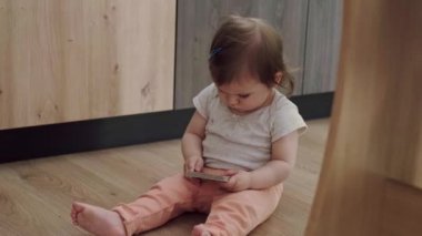 Yerde oturan ve elinde konsantre olduğu bir hikaye kitabı tutan küçük bir kız çocuğu. Güzel surat..