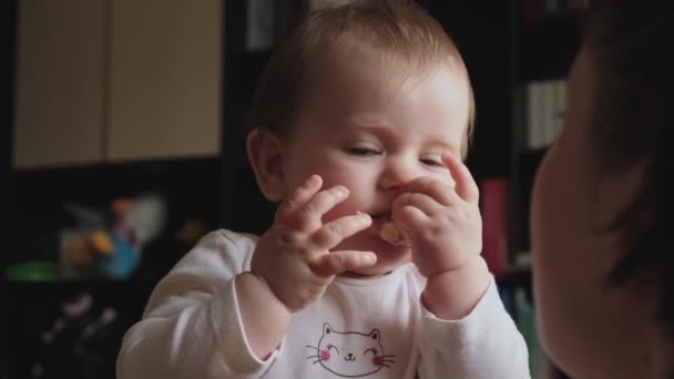 Baby in her mothers arms eating banana. Smiling happy child. Baby care. Healthy food. Natural organic nutrition. Sweet fruits. — Vídeo de Stock