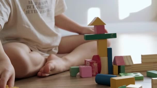 特写与男孩用手用玩具建筑砖建造塔楼，享受闲暇和游戏时间。幼儿和幼儿的教育游戏。儿童 — 图库视频影像