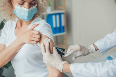 Woman with face mask getting vaccinated against the coronavirus. Medical treatment. Doctor hand. Coronavirus vaccination. Virus protection.