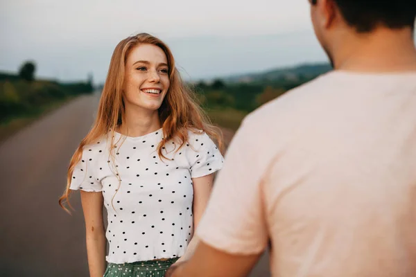 Pareja que se reunió fuera de la ciudad en el camino al campo. Foto al aire libre de pareja joven caminando. Retrato para el diseño de estilo de vida. — Foto de Stock