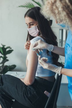 Doktor, beyaz bir kadına kovid 19 aşısı enjekte ediyor. Aşılanmış biri. Tıbbi sağlık hizmeti konsepti. Pandemik önleme.