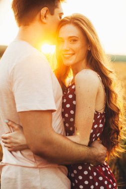 Buğday tarlasında bekleyen, kucaklaşan güzel bir çift. Aile bakımı. Buğday tarlası.