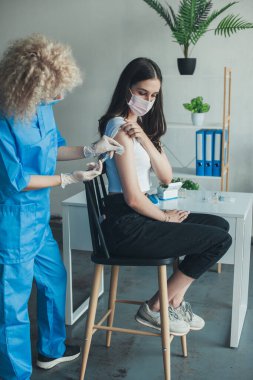 Kadın, silah hastasına şırınga enjekte ederek aşı oluyor. Coronavirus aşısı. Aşılama, aşılama, hastalık önleme kavramı