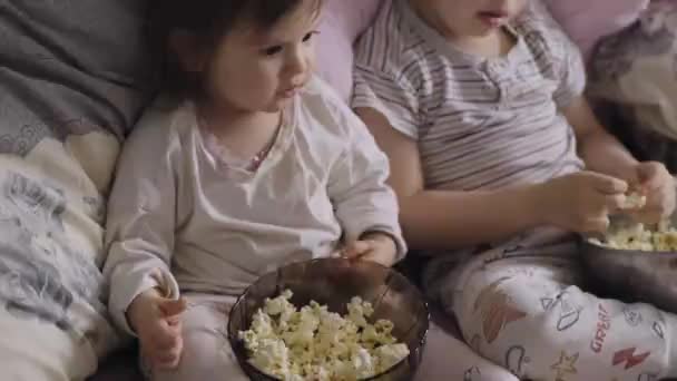 Bebek Kız Erkek Kardeşi Yatak Odasında Film Izlerken Patlamış Mısır — Stok video