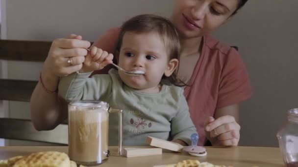 Matka Śniadanie Dzieckiem Trzymając Ramionach Karmiąc Łyżką Dając Piankę Cappuccino — Wideo stockowe