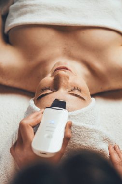 Modern ekipmanlar kullanarak kaplıca salonunda işlem yapan bir doktor. Kız yüz tedavisi. Cilt bakımı.