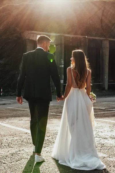 結婚式後の山道を歩いて花嫁と新郎の手を保持バックビュー 後ろからの眺め 結婚式の日コンセプト — ストック写真