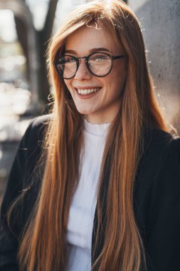 Kızıl saçlı, hafta sonunun tadını çıkaran kızıl saçlı bir iş kadınının portresi. Sokak tarzı. İş portresi. Güzel surat..