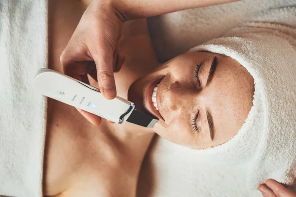 Kozmetik kliniğinde ultrasonik deri soyan genç bir kadın. Estetik kozmetoloji, yüz bakımı. Cilt bakımı.