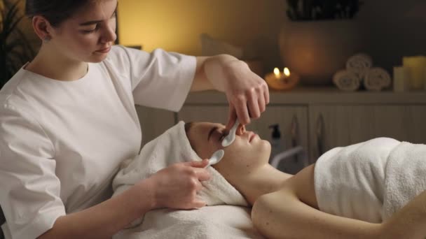 Mujer Recibiendo Masaje Facial Con Cucharas Porcelana Salón Spa Tratamiento — Vídeo de stock