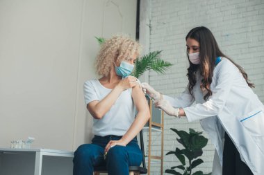 Hemşire elleri antiviral enjeksiyondan önce kolunun üst kısmında şırınga ve temiz deri tutuyor. Sağlık hizmeti konsepti. Antivirüs konsepti. Corona Virüs Aşılama