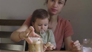 Mom with her baby daughter have a breakfast in the morning. Baby care. Healthy meal. Happy family. Baby development.