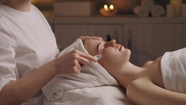 Beautiful Woman Getting Facial Massage Porcelain Spoons Spa Salon Beauty — стоковое видео
