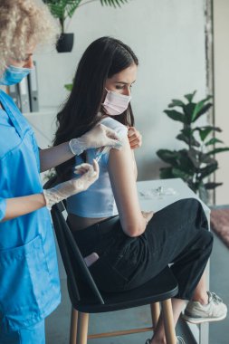 Hastanın omzunda aşı yapan bir doktorun portresi. Coronavirus aşısı. Coronavirus önleme.