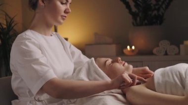 Güzellik salonundaki güzellik uzmanı bu işlemi hastaların omuzlarında porselen kaşıklarla yapıyor. Güzellik tedavisi. Kozmetik güzellik salonu.