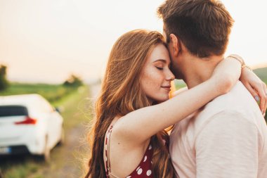Man and woman hugging in holiday honeymoon trip on the road outdoors. Honeymoon trip. Couple embracing on road travel. Happy family.