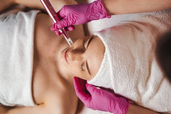 Top view of a woman getting facial mesotherapy treatment by professional dermatologist. Skin beauty and health. Facial aesthetic procedure concept