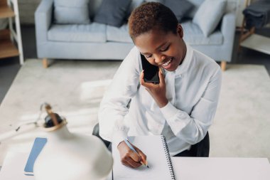 Afro iş kadını iş yerinde telefon görüşmesi yapıyor. Şirket iş teknolojisi. İnternet teknolojisi.