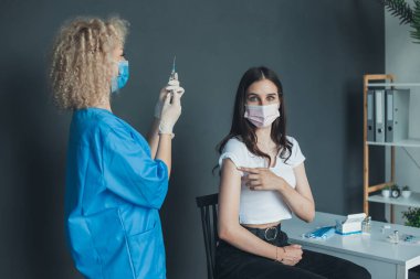 Corona virüsüne karşı Pfizer aşısı hazırlayan hemşire kadın doktor hastanede bir kadın hastaya uygulanacak. Coronavirus aşısı. Salgın