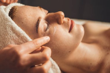 Kozmetik uzmanının yakın plan portresi spa salonundaki kadın müşteriler için canlandırıcı yüz işlemleri yapıyor. Güzellik tedavisi. Estetik kozmetoloji, yüz bakımı. Yüz Yüzü