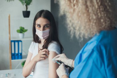 Doctor inject vaccine to patients arm at the hospital. Virus, epidemic, disease. Coronavirus vaccination. Pandemic prevention.