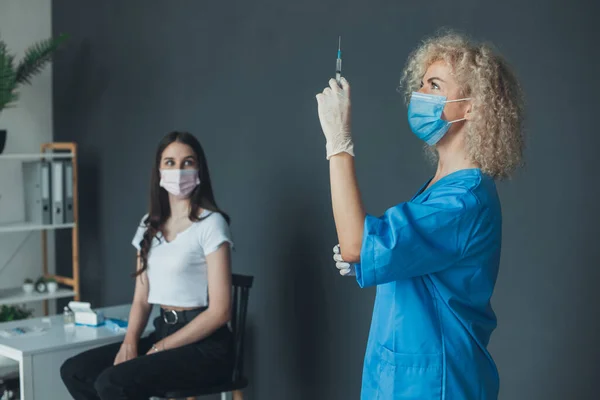 Curly Haired Nurse Preparing Coronavirus Vaccine Woman Patient Vaccination Center — Fotografie, imagine de stoc