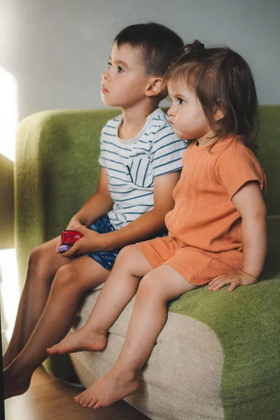 Two Kids Sitting Sofa Watching Television Home Spent Quality Time — Zdjęcie stockowe