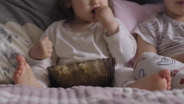 Little Girl Her Brother Pajamas Eating Popcorn Bed Watching Sitting — Stok video