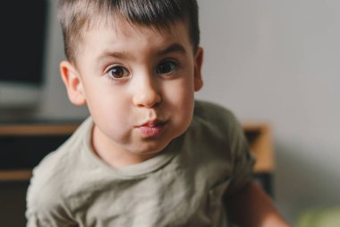 Little caucasian boy smiling at the camera with mouth full of food snacks. Healthy eating. Healthy meal. Sweet food. Happy face.