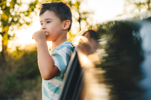 Little Boy Stuck Out His Head Car Trip Eating Snacks — Stok fotoğraf