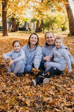 Family posing in autumn park having fun. Happy family, childhood. Parent, child. Smiling girl. Autumn forest.