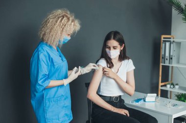 Patient getting vaccinated with covid vaccine intramuscular injection during doctors appointment in hospital. Vaccine, human clinical trial and vaccination