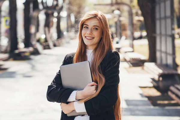 Smiling Ginger Woman Looking Away Carries Laptop Waits Someone Park — Stockfoto