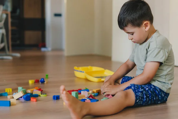 Concentrated Boy Playing Toys Sitting Warm Floor Modern Living Room — Fotografia de Stock