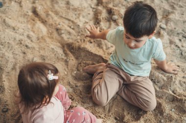 Top view of two little kids playing the sand, outdoor freeplay for kid development and social skill for childhood. Baby development. Preschooler outdoor. Active