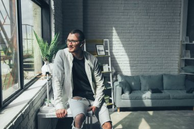Smiling caucasian businessman portrait leaning against a table sitting alone in his office. Business portrait. Businessman manager employee.