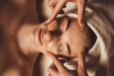 Top view photo of cosmetologist making facial massage treatment for patient woman face at spa salon. Beauty treatment. Facial beauty. Beauty skin.