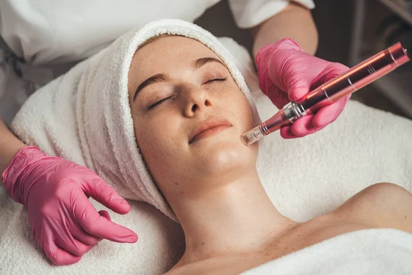 Woman getting facial treatment of chin zone with derma pen at spa salon. Skin treatment. Medicine medical health. Beauty skin. Woman beauty face.