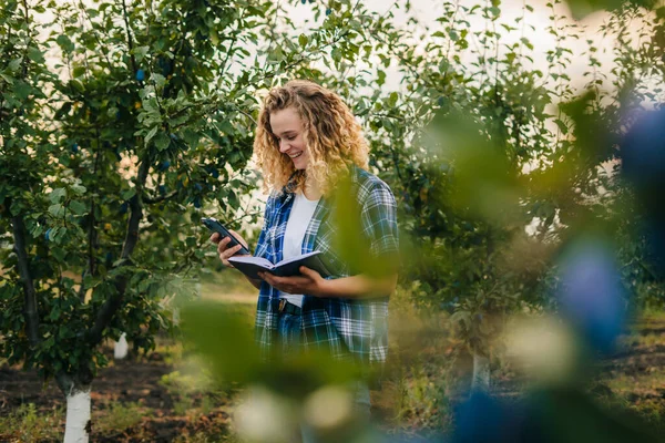 Woman Agronomist Using Mobile Phone Making Notes Notebook Standing Plum — Stockfoto