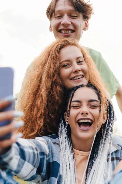 Three teenagers having fun and taking selfie, enjoying a day outdoors. Social media app. Beauty portrait.