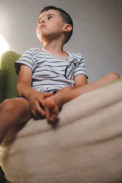 Portrait Adorable Caucasian Boy Sitting Sofa Home Looking Away Attentively — 스톡 사진