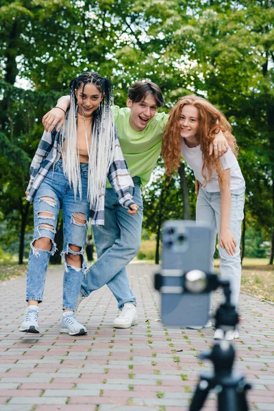 Group of friends having fun taking photo with mobile phone doing funny faces. Free time in weekend. Friendship, people, and technology concept