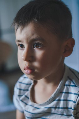 Close-up portrait of a concentrated boy looking at the TV obsessed with movies and games on the Internet. Bad habits. Covid 19 pandemic. Screen time, Watching