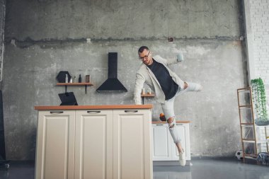 Man drinking morning coffee and filling himself with energy jumping and enjoying a perfect morning. People lifestyle concept. Healthy breakfast. Business